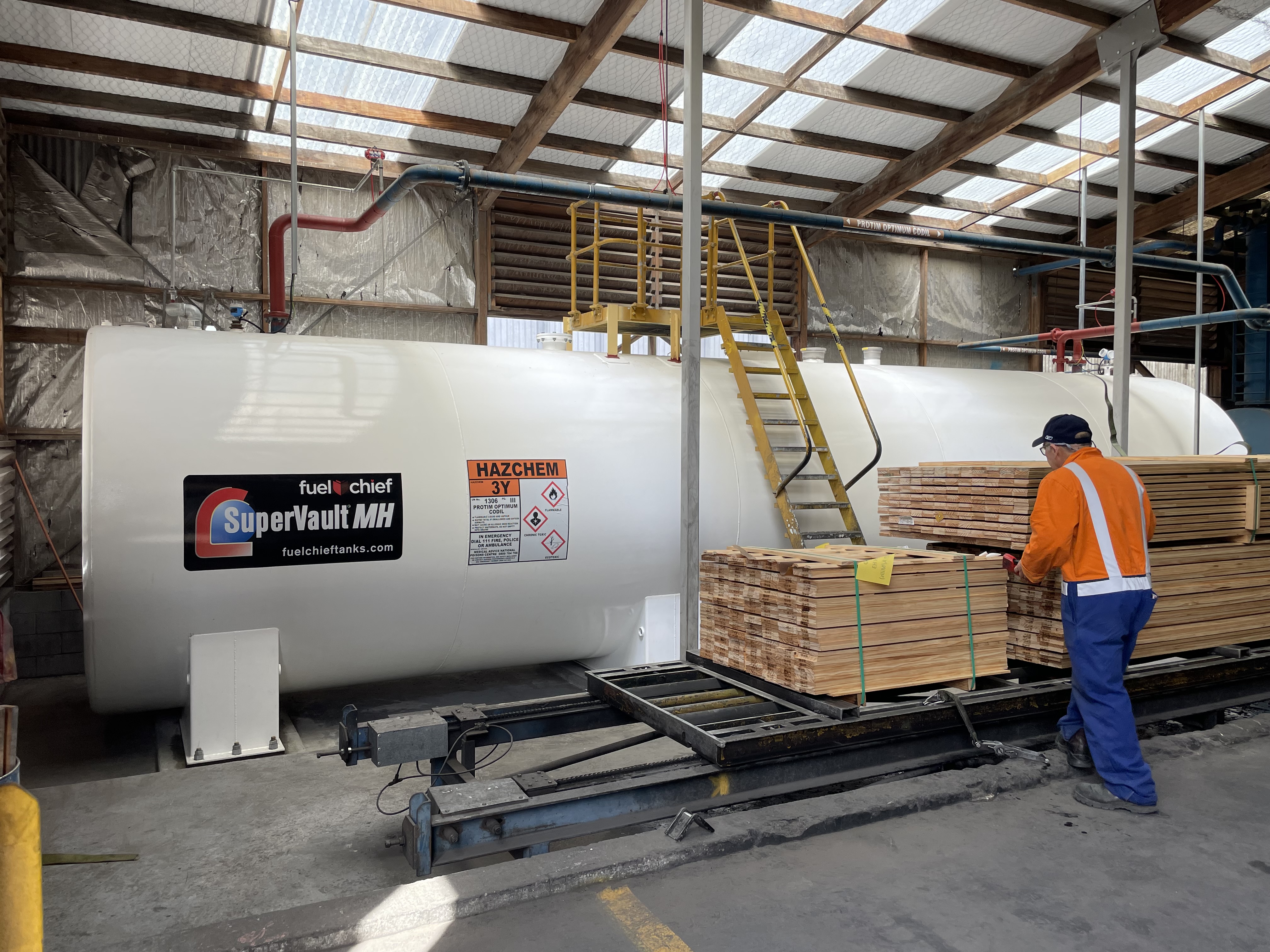 Worker beside a white SuperVault MH tank in a timber factory