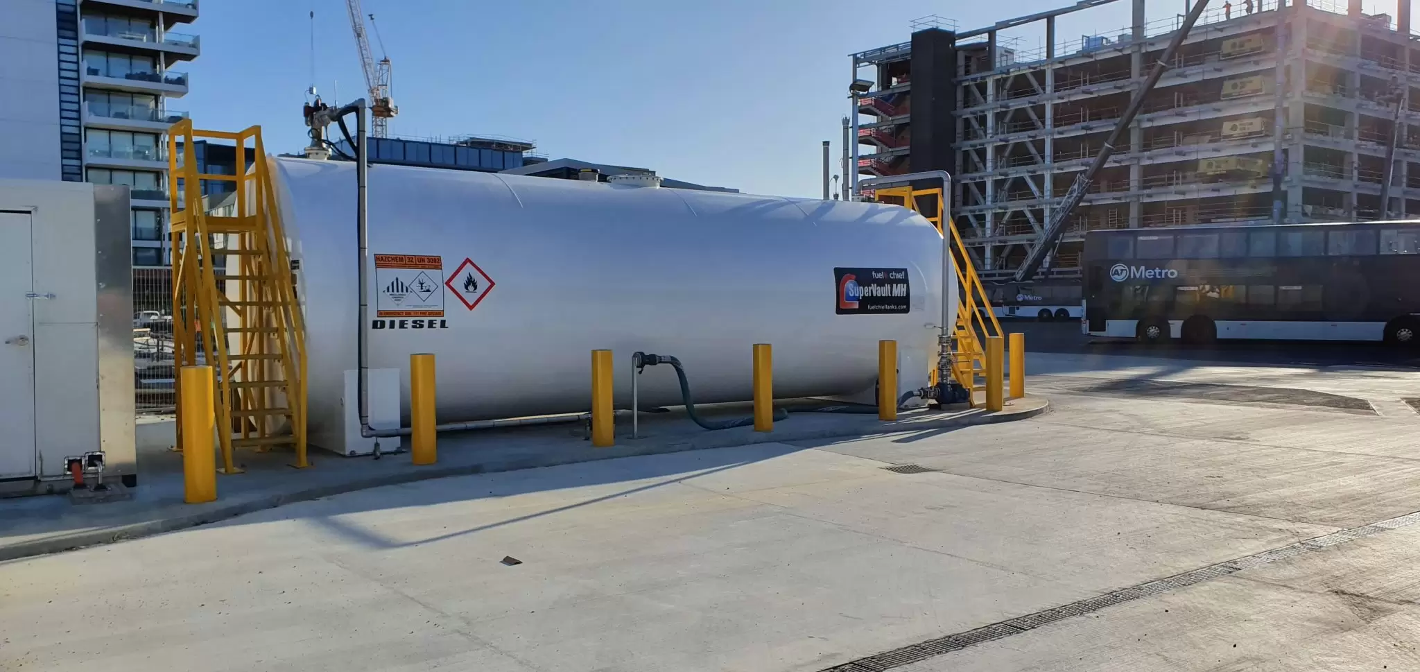 White horizontal fuel tank with stairs at a city bus depot