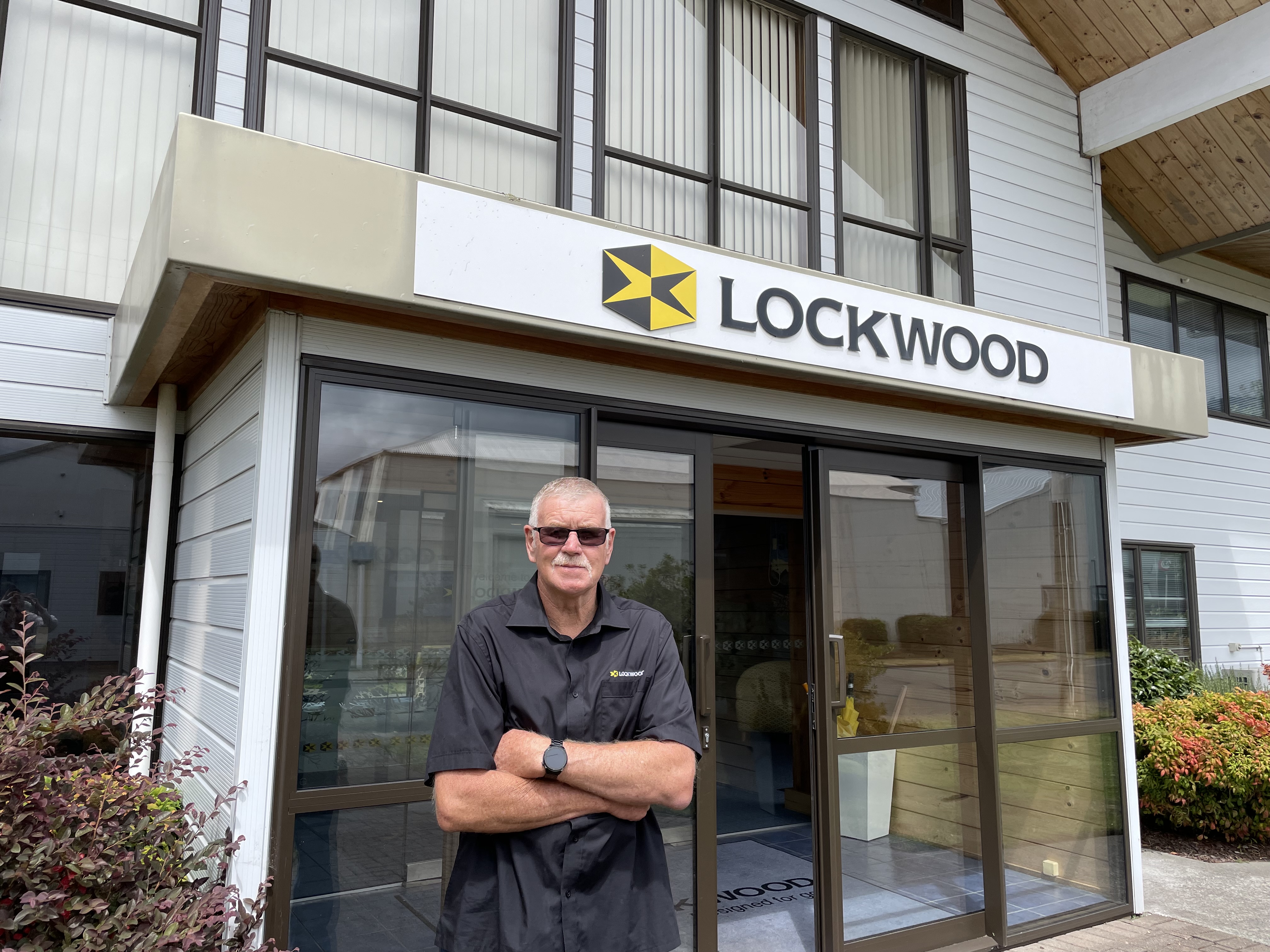 Man with folded arms at the entrance of the Lockwood building