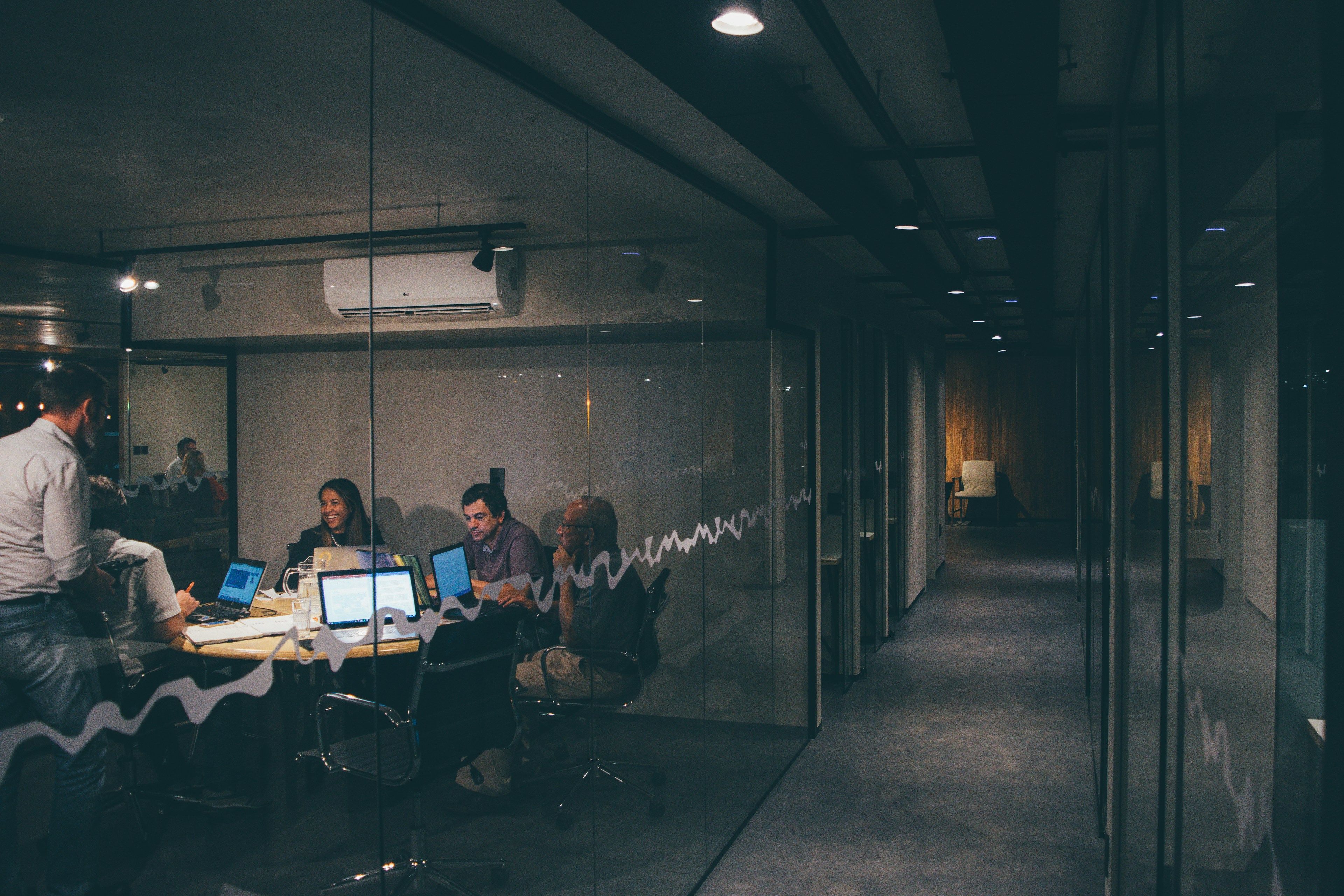 Office team working at a table behind a glass wall