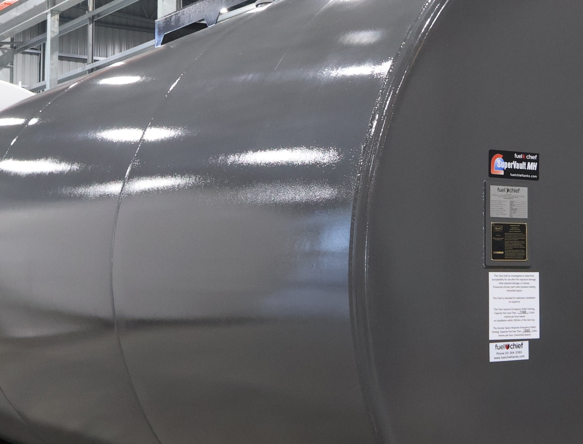 Grey horizontal tank with its labels in a factory